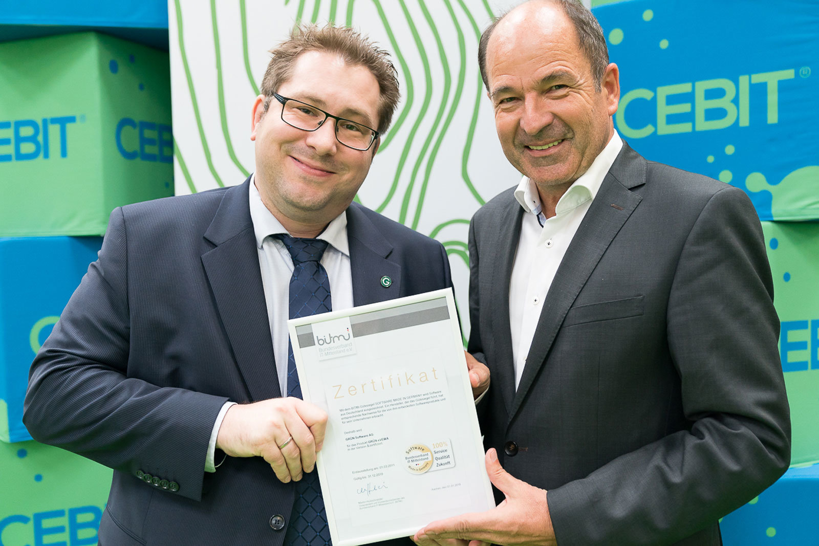 Olivier Chatain, Sales Director of GRÜN Software AG, accepts the BITMi seal of approval from Martin Hubschneider, Vice President and Board Member of BITMi.