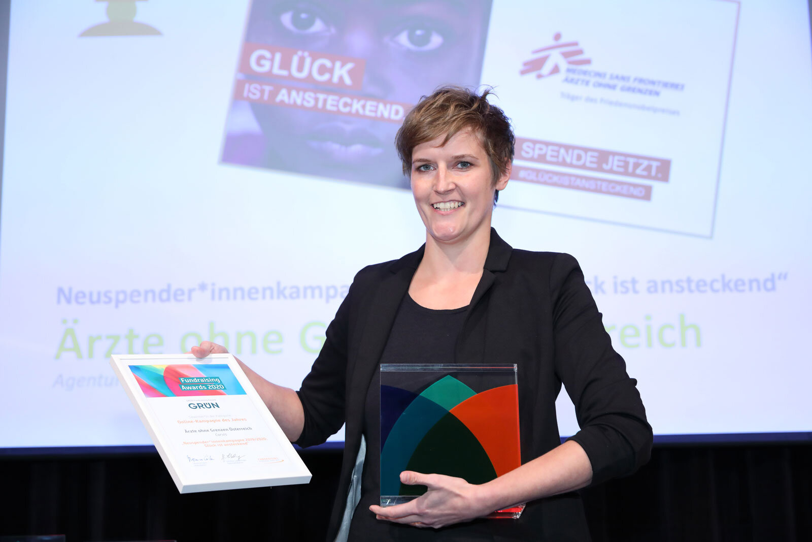 Andrea Buhl-Aigner, Leitung Digital Communications Unit bei Ärzte ohne Grenzen Österreich, mit der Urkunde und dem Pokal des GRÜN Fundraising Awards