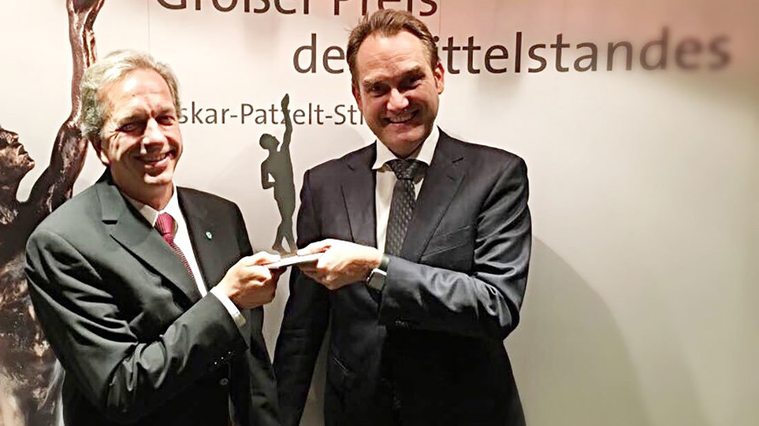 Dirk Hönscheid (links) und Oliver Grün (rechts) mit der Preisträgerstatue als Finalist des „Großer Preis des Mittelstandes“.