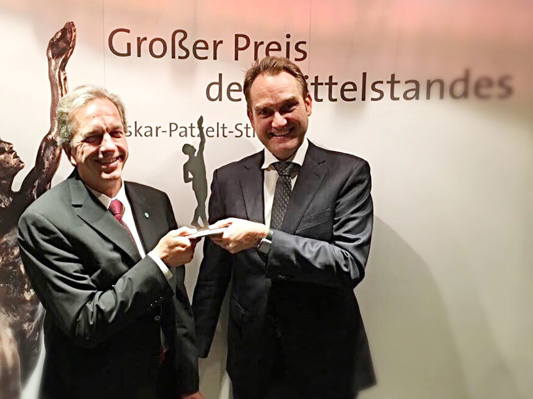 Dirk Hönscheid (links) und Oliver Grün (rechts) mit der Preisträgerstatue als Finalist des „Großer Preis des Mittelstandes“.